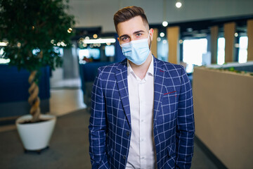 Businessman and the coronavirus epidemic. of a young business man in a disposable mask. Man Protects Against COVID 19 in Modern Buildings