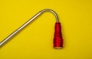 Folding portable torch light on yellow background