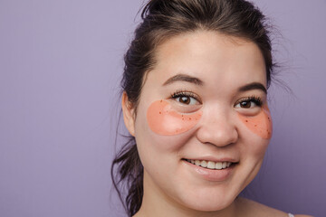Young brunette east asian woman wearing skincare under eye patch