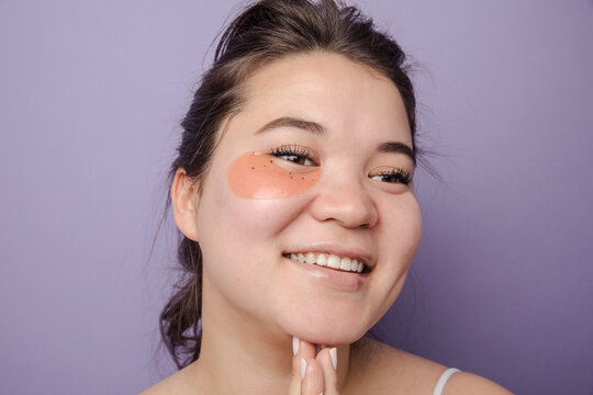 Young brunette east asian woman wearing  skincare under eye patch