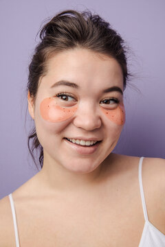 Young brunette east asian woman wearing  skincare under eye patch
