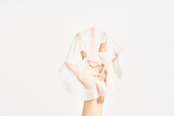 Cosmetic sheet mask on female hand