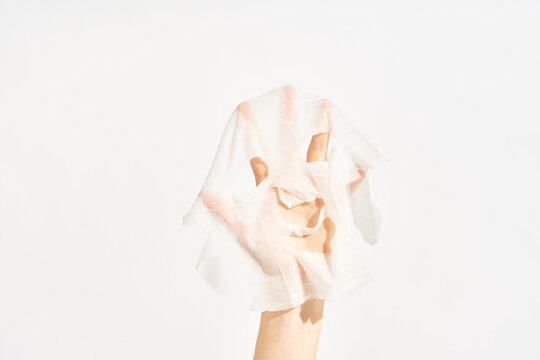 Cosmetic sheet mask on female hand