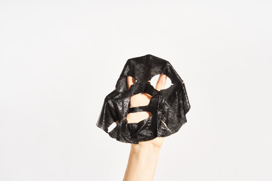 Woman with black sheet skin care mask
