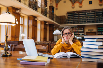 Stressed college student tired of hard learning with books and laptop in exams tests preparation, overwhelmed high school teen girl exhausted with difficult studies or too much homework.