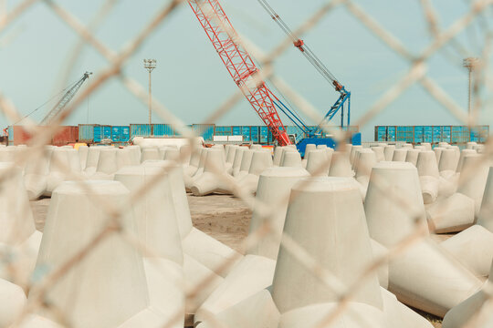 There are tetrapods and cranes in the harbor