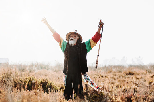 Happy hippie rastaman standing on field