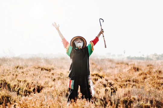 Happy hippie rastaman standing on field