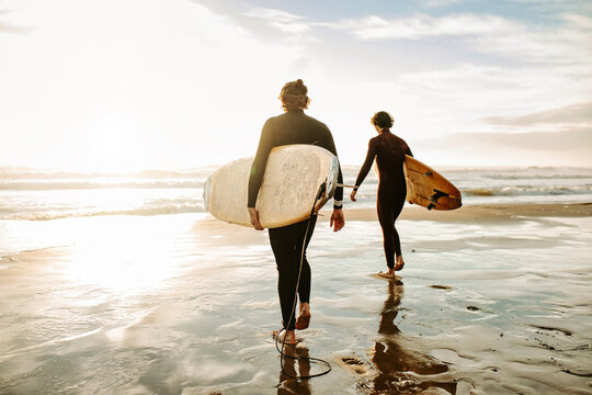 Anonymous surfer friends at the beach with surfboards