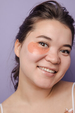 Young brunette east asian woman wearing  skincare under eye patch