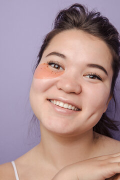 Young brunette east asian woman wearing  skincare under eye patch