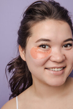 Young brunette east asian woman wearing  skincare under eye patch smiling