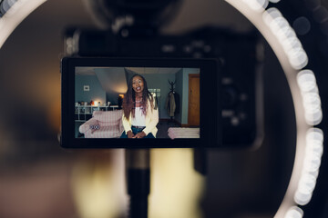 view of camera recording a video of a woman who is vlogging.