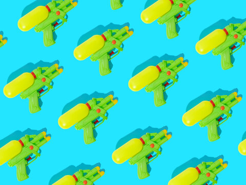 Row of colorful water guns on blue background