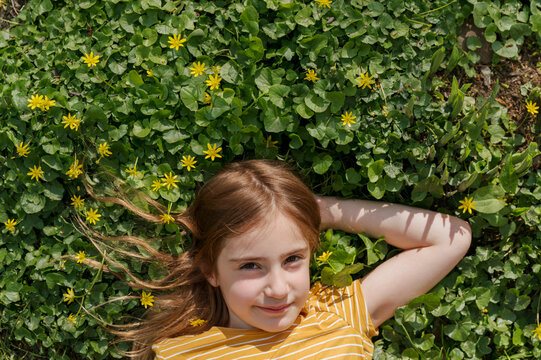 Girl Among Yellow Flowers in a Field of Clover