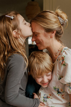 Portrait of Mother Snuggling with her Son and Daughter