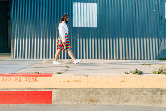 Teenager with rainbow skirt walking outdoors