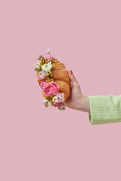Woman holding croissant with flowers