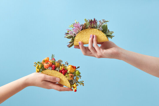 Women holding tacos with flowers