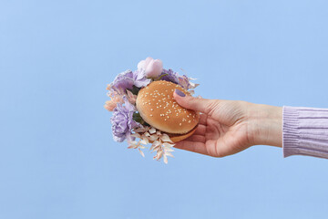 Woman holding burger with flowers