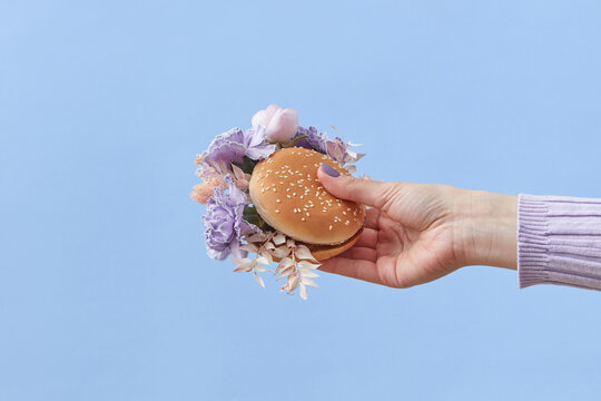 Woman holding burger with flowers