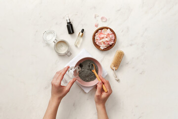 Woman making facial mask with black clay