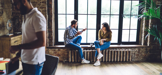 Focused coworkers resting on windowsill