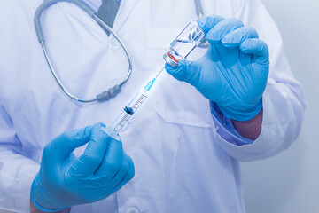 Doctor wearing blue gloves is holding  virus medicine Corona and syringes