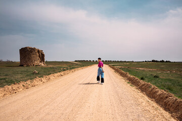 Young woman walks along a dirt road