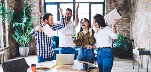 Cheerful diverse colleagues rejoicing successful collaborative business results