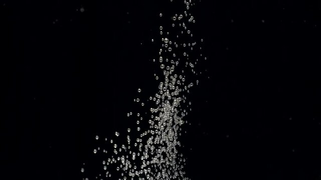 Slow motion numerous small air bubbles in water rising up to the surface on isolated black background. Slowmotion air bubbles floating under transparent water bubbles in aquarium