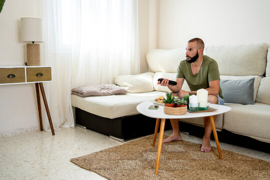 Young man zapping at home