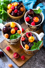 Fototapeta na wymiar Summer breakfast or dessert. Chocolate cupcake in a mug is served with fresh summer berry raspberries and cherries.