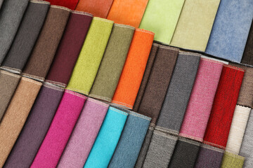 Fabric samples of different colors as background, top view