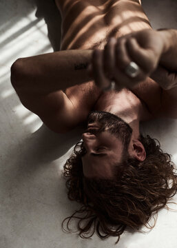 Sexy portrait of a young beareded man on the floor