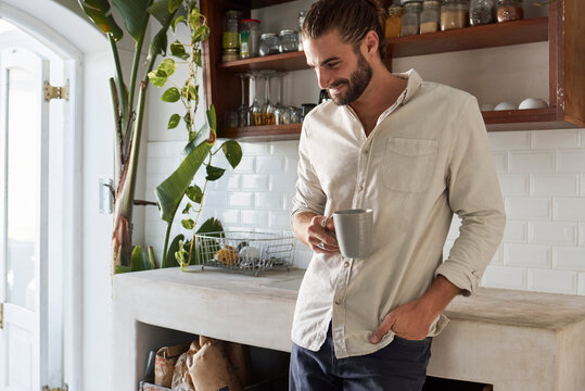 Young bearded man relaxing with a coffee at home