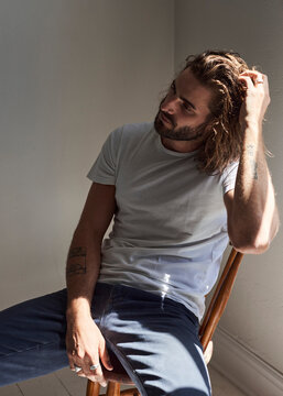 Bearded man brushes his hair back