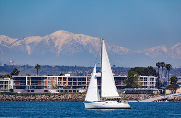View of the land in Southern California at Marina del Rey with the snow capped mountains in the background. 