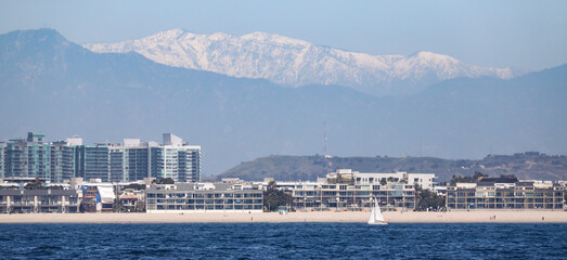 View of the land in Southern California at Marina del Rey with the snow capped mountains in the background.