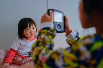 Little girl taking photo with a polaroid camera