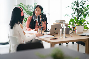 Female colleagues recording podcast in studio