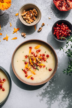 Asparagus soup topped with pomegranate seeds and marigold petals