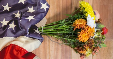 American flag and bunch of flowers on wooden background