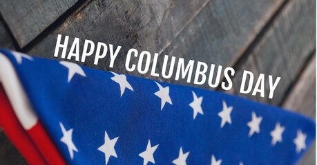 Fototapeta na wymiar Happy columbus day text against folded american flag on wooden background