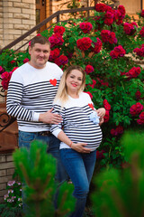 Young pregnant woman with her husband outdoors.