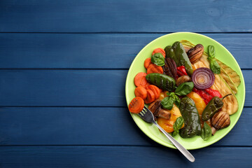 Delicious grilled vegetables on blue wooden table, top view. Space for text