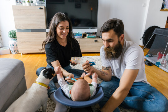 Family lifestyle, young millennial parents feeding baby at home 