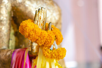Buddha statue with raw of Brass. Hand of buddha statue with. marigold garland and rose garland....