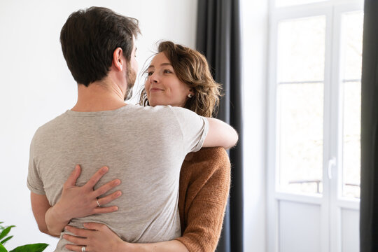 Glad Couple Hugging In New Apartment