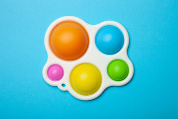 Simple dimple or pop it game on pink background. Top view of Push Pop Fidget Toy on color background. Silicon sensory anti stress toy